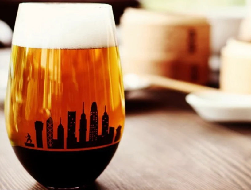 Glass of beer with a city skyline design on a wooden table